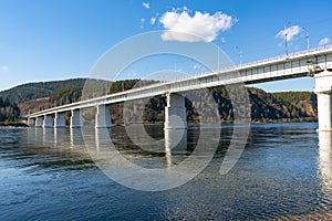 Long concrete bridge over the river on massive pillars.