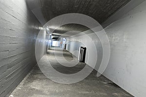 Long concrete pedestrian corridor that passes under the train station in Melide in Switzerland