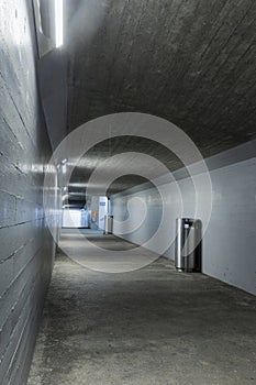 Long concrete pedestrian corridor that passes under the train station in Melide in Switzerland