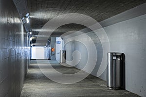 Long concrete pedestrian corridor that passes under the train station in Melide in Switzerland