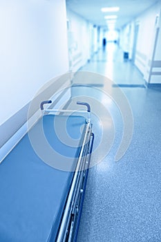 Long corridor in hospital with surgical gurney.