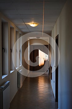A long corridor in the hotel with Windows and doors.