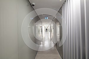Long corridor in modern office building. Blurred business woman walking down the hall.  Workplace and lifestyle concept