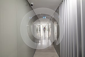 Long corridor in modern office building. Blurred business woman walking down the hall.  Workplace and lifestyle concept