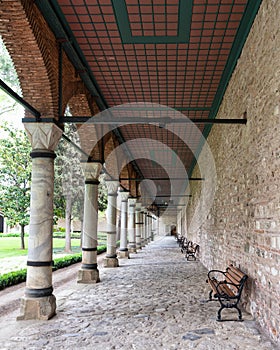 Long covered paved walkway with columns and benches, located in the courtyard of Topkapi Palace, Istanbul, Turkey