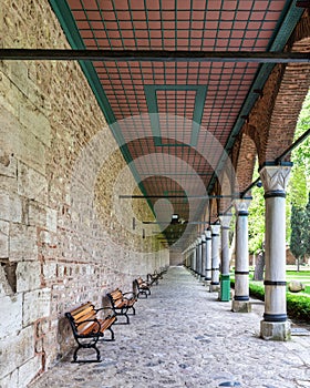 Long covered paved walkway with columns and benches, located in the courtyard of Topkapi Palace, Istanbul, Turkey