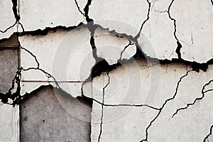 Long crack on the grey grunge cement wall. Abstract damaged wall texture with traces of destruction from old age and