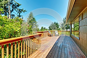 Long Deck, terrace with wood railings and green landscape.