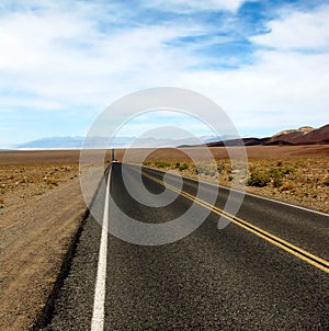 Long desert highway leading into Death Valley National Park, USA