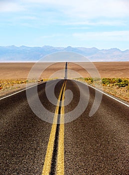 Long desert highway leading into Death Valley National Park, USA