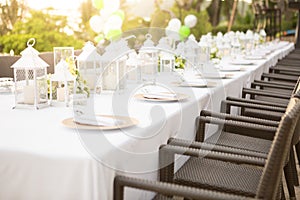 Long dining table at wedding. Tableware decorations with white tablecloths at outdoor wedding