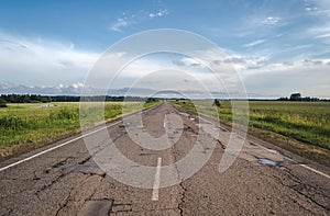 Long driveway in field, rural road, landscape with clouds