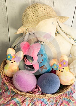 long eared hat wearing Easter bunny, colorful Easter eggs, assortment of colorful peeps.