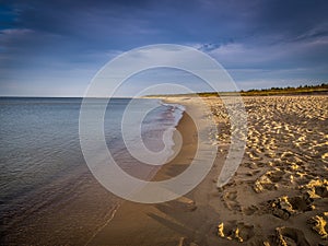 Long, empty and clean sand Stogi beach in the sunset near Gdansk, Poland with dramatic blue sky