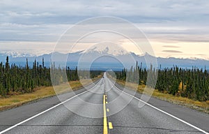 Long empty road with mountain range in the background