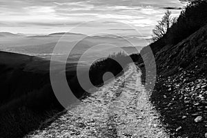 A long, endless mountain road with distant mountains in the background