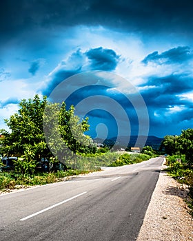 Long endless road in countryside with no traffic with clouds