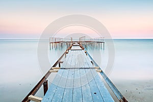 Long esposure view of a old jetty in a calm sea with gentle sky, soft colors