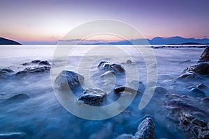 Long exposed photo of stones in the water of Mediterranean sea a