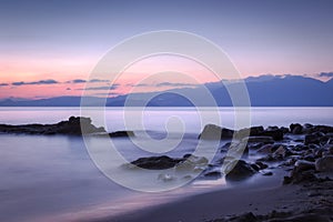 Long exposed photo of stones in the water of Mediterranean sea a