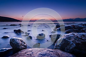 Long exposed photo of stones in the water of Mediterranean sea a