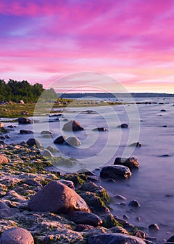 Long Exposure of the Baltic sea landscape. Stones, waves and sunset sun sky. The Gulf of Finland. Summer seascape