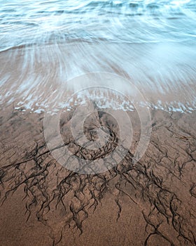 A Long exposure captures the waves and incoming tide on Four Mile Beach