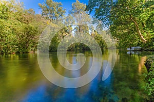 Long exposure of Cetina river in Omis Almissa, Croatia, Europe with a boat/ green/water/river/sky/blue