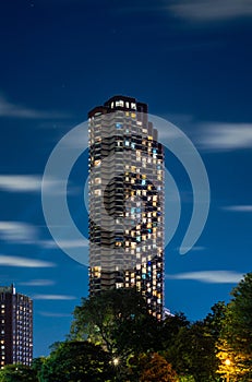 Long exposure of clouds moving across a dark blue sky over a highrise residential building in the Lakeview neighborhood along Lake