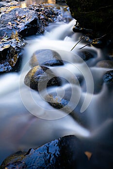 Long exposure effect of flowing water through the rocky creek