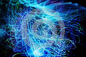 Long exposure of fiber optical light cables in LED neon blue glow. Optics with spiral motion effects for fast data