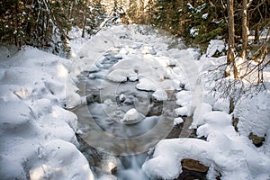 Long exposure of flowing cold frozen water in mountain stream