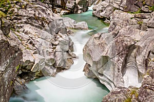 Long exposure of flowing water in Verzasca River at Lavertezzo - clear and turquoise water stream and rocks in Ticino - Valle