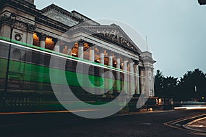 Long exposure of a green bus passing in front of the arhitecture museum in cambridge city