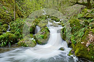 Long exposure image of beautiful stream of water running through cascades of rocks and stones.