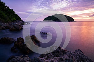 Long exposure image of Dramatic sky seascape with rocks in the foreground sunset or sunrise scenery background