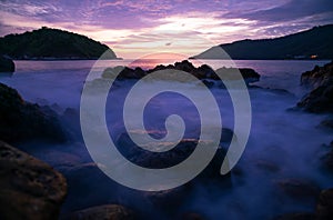 Long exposure image of Dramatic sky seascape with rocks in the foreground sunset or sunrise scenery background