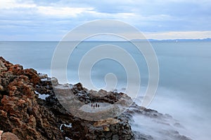 Long exposure image of a rocky beach in Anilao