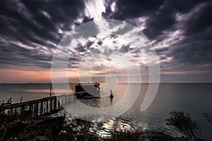 Long exposure of magic sunrise over the ocean with a hut in the