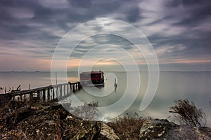 Long exposure of magic sunrise and a wooden hut.