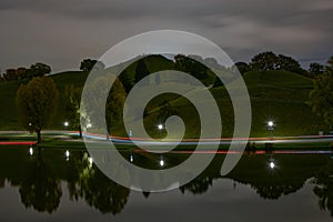 Long exposure of the olympiaberg in Munich. Olympiaberg at night. Long exposure of cyclists passing the Olympiaberg in Munich