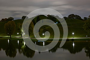 Long exposure of the olympiaberg in Munich. Olympiaberg at night. Long exposure of cyclists passing the Olympiaberg in Munich