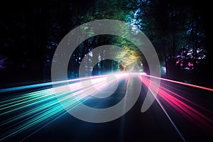 a long exposure photo of a road with trees in the background and light streaks on the road at the end of the line of the road