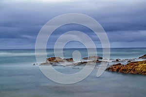 Long exposure photo of rocks and ocean