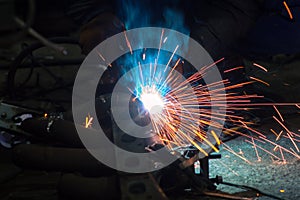 long exposure photo welder performs welding works of metal structures for custom cars