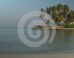 Long exposure picture from the beach with a cluster of coconut trees in the background