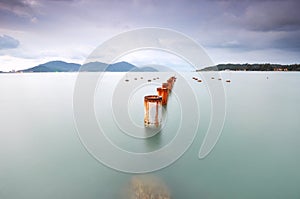 Long exposure of piling pole for unfinished wooden jetty facing