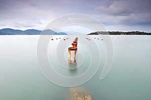 Long exposure of piling pole for unfinished wooden jetty facing