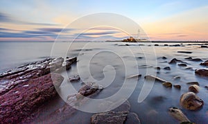 Long exposure of rocks on the beach at St.Mary`s Lighthouse photo