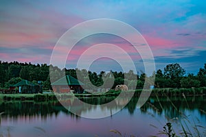 Long exposure scenic view of small red house on the bank of still pond